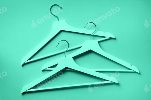 Preview: Top view of white clothes hangers on trendy green and turquoise color. Flat lay. Minimalism style