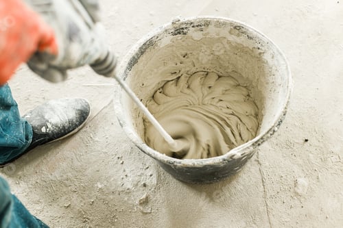 Preview: Worker mixing gypsum plaster with water for plastering walls