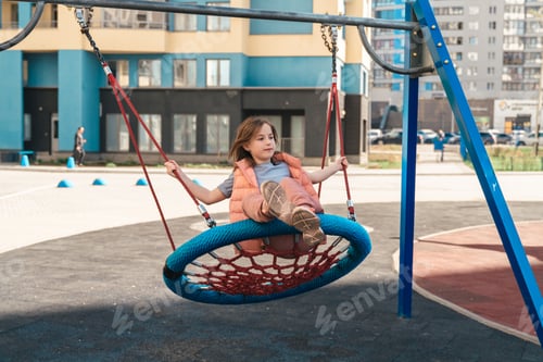 Preview: cute girl walks and swings on a swing outdoors