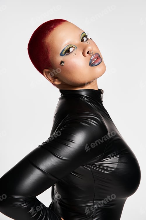 Preview: Bold young woman with pink hair and edgy style posing confidently in studio setting