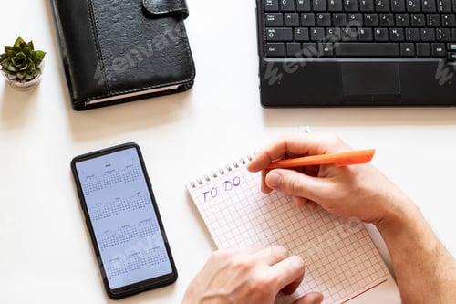 Preview: Overhead workspaces. Top view of human hands holding a pen to write a list of business ideas