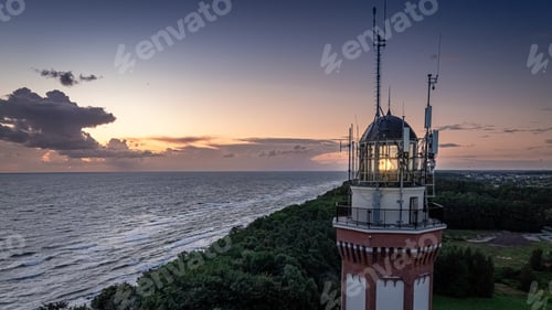 Preview: Light beam from lighthouse by Baltic Sea after sunset