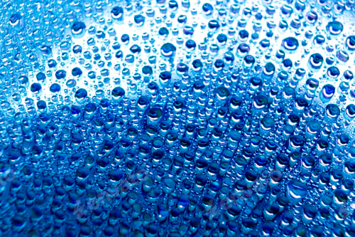 Preview: Selective focus shot of colorful reflective water drops on a digital disc surface