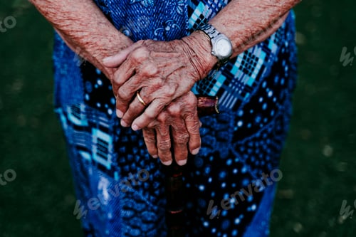 Preview: close up of old lady hands holding a stick outdoors