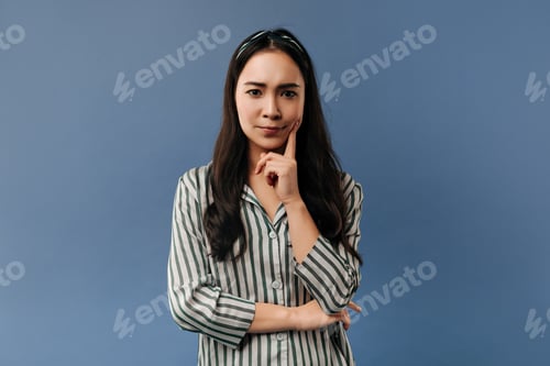 Vista previa: Serious young cool lady with brunette hair in comfortable long sleeve shirt looking into camera on