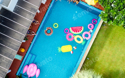 Preview: Group of diverse friends enjoying the pool with inflatable tubes