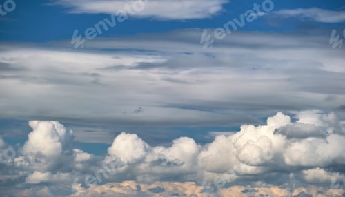 Preview: Bright landscape of white puffy cumulus clouds on blue clear sky.