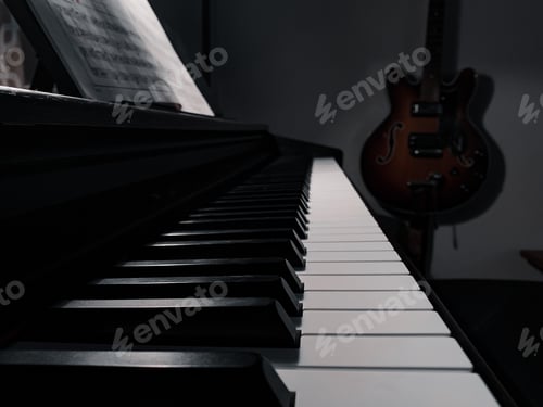 Preview: Piano keys with sheet music and a hanging guitar in the background