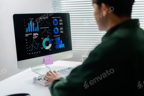 Preview: Professional reviewing graphs and charts on a computer monitor
