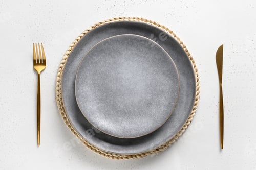 Preview: Elegance table setting with empty gray plate with golden cutlery.