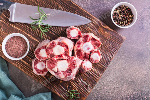Preview: Raw sliced oxtail, spices and rosemary on a wooden board top view