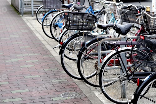Preview: A group of bicycles lined up in a row on the sidewalk.