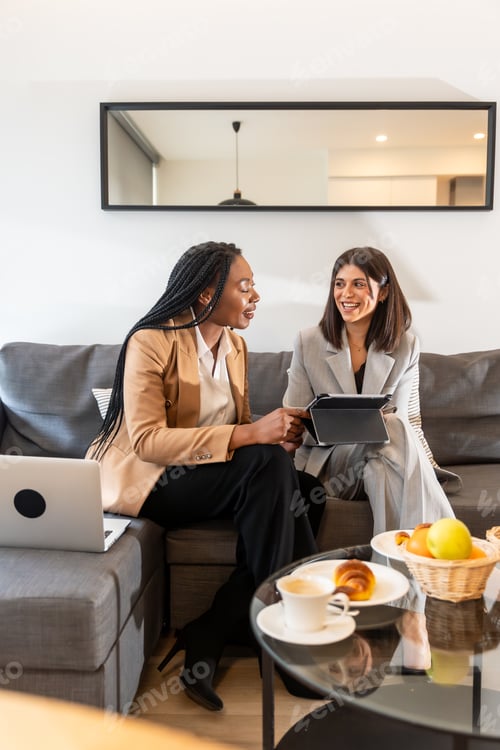 Preview: Businesswomen having meeting with tablet and laptop in hotel room