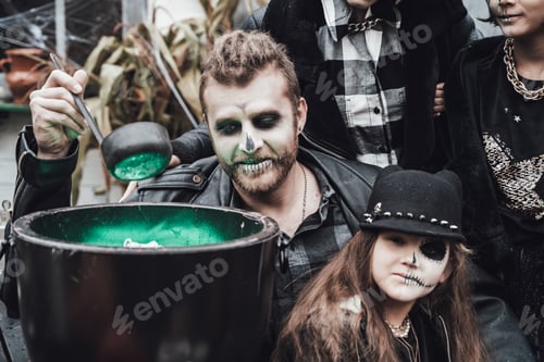 Preview: Scary family, mother, father, daughters celebrating halloween. Cauldron of potion.Terrifying black s
