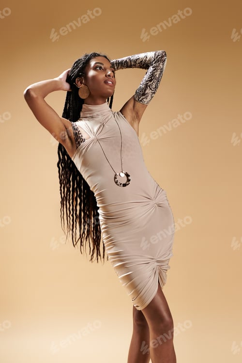 Preview: Stylish young woman showcases trendy attire against a warm, neutral backdrop