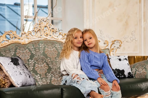 Preview: Two Cute Girls Sitting on an Elegant Couch