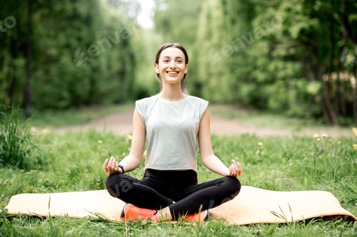 Preview: Young woman doing yoga in the park