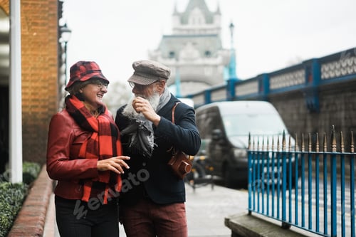 Preview: Happy senior couple having fun walking outdoors by the city - Focus on woman hand