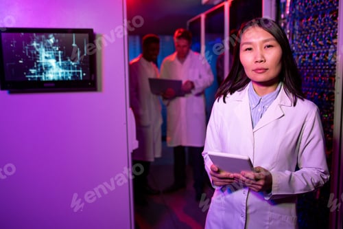 Preview: Modern Asian woman in lab coat working in server room