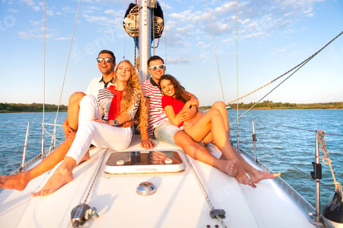Preview: Smiling friends on yacht deck and greeting