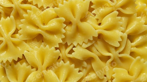 Preview: Background yellow pasta in shape of butterflies close-up