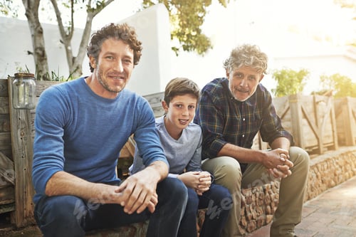Preview: Portrait of a young boy sitting with his father and grandfather in their backyard