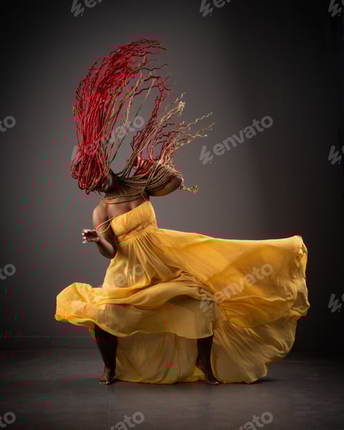 Preview: African American female wearing a bright yellow dress with her long red hair blowing in the wind