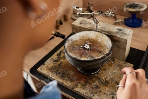 Preview: A skilled artisan meticulously creates jewel pieces in a well lit workshop during midday