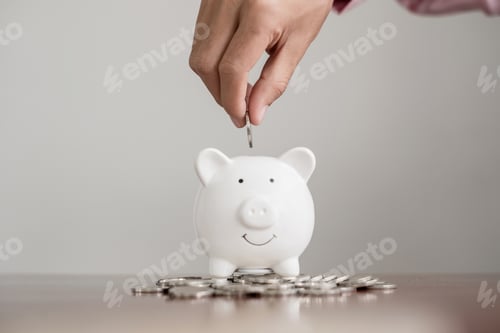 Preview: The hand of a businessman puts coins in a piggy bank, saves money with coins, steps into
