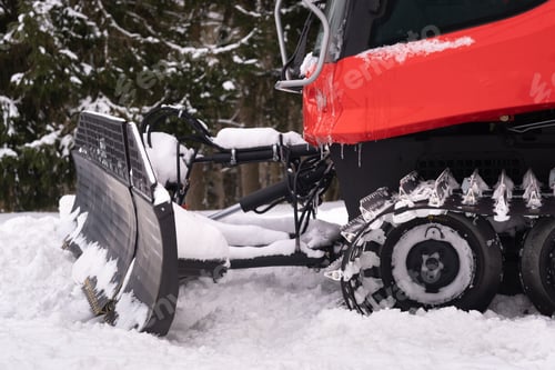 Preview: The bucket of a snowplow on tracks, standing in the forest in winter