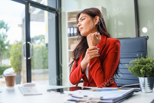 Preview: An businesswoman sits at table, working long hours as a financial analyst on computers tablets