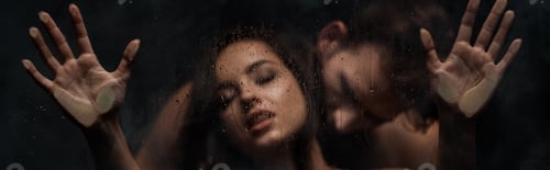 Preview: beautiful seductive couple hugging behind wet glass