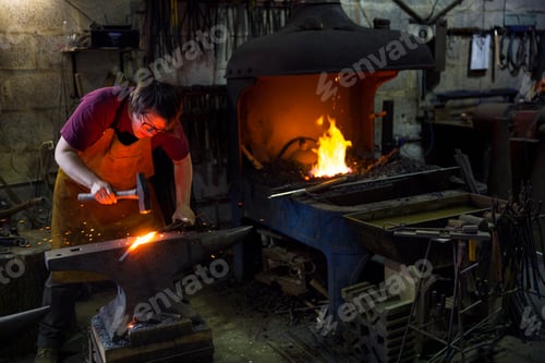 Preview: A blacksmith striking red hot metal on an anvil inside a workshop.