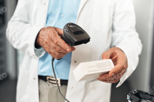 Preview: Senior pharmacist scans medicine package at checkout counter