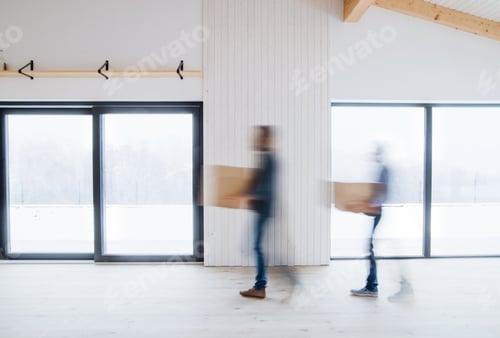 Preview: Two men walking with cardboard boxes when furnishing new house. Motion blur.