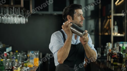 Preview: Smart bartender in black apron preparing cocktail