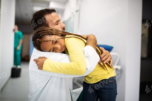 Preview: Doctor having conversation with sad little girl at the hospital. Doctor consoling child