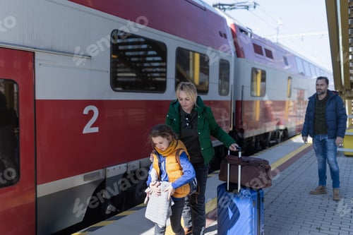 Preview: Ukrainian immigrant family with luggage waiting at train station, Ukrainian war concept.