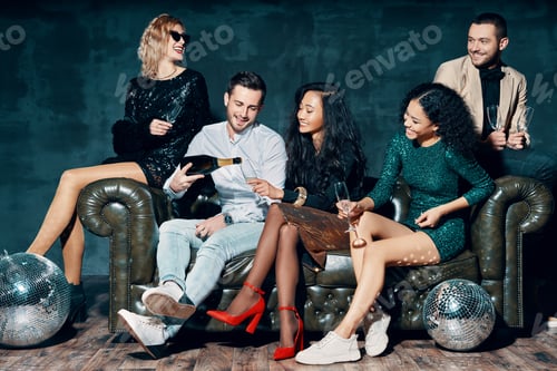Preview: Diverse group of friends having fun enjoying party and pouring champagne