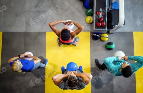 Preview: Young sporty people working out together with kettle bells in a gym