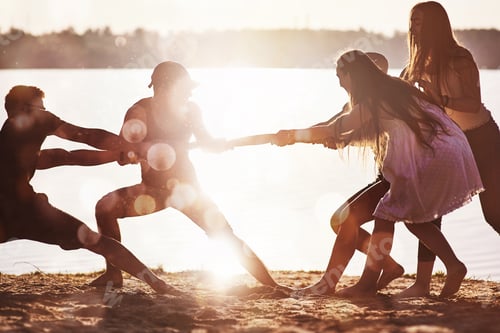 Preview: Happy friends have fun on the beach - Young people playing in open air water on summer holidays