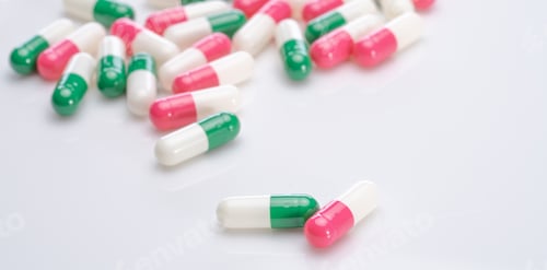 Preview: Capsules pill spread on white background. Prescription drugs. Capsule pill production. Green, pink