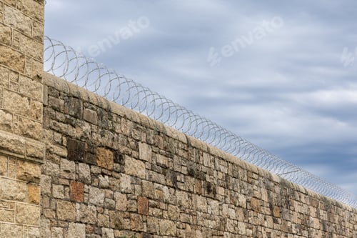 Preview: Barbed wire fence on high wall perimeter for security and protection
