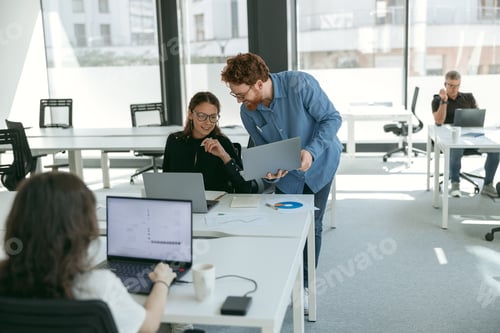 Preview: Two business colleagues working together on project in office while use laptop. Teamwork concept