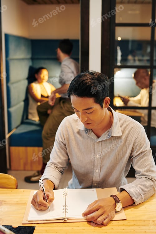 Preview: Serious businessman filling journal