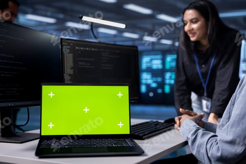 Preview: Focus on green screen notebook used by data center admins in blurry background