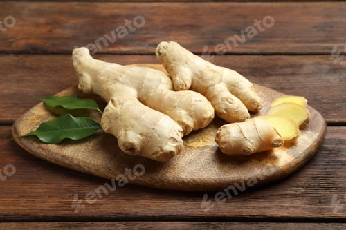 Preview: Cut and whole fresh ginger with leaves on wooden table