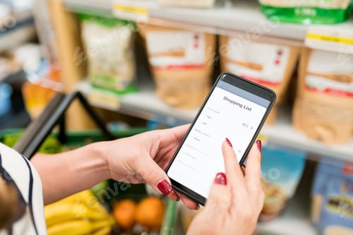 Preview: Female Customer Using Mobile Phone In Supermarket