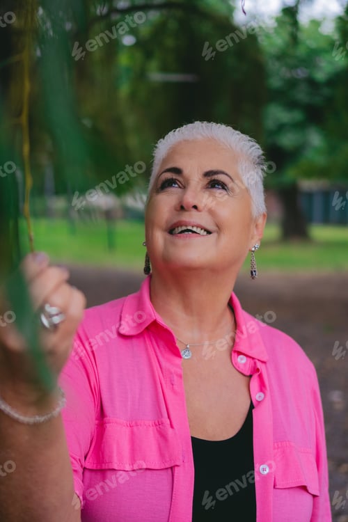 Preview: portrait of older Latin woman looking at nature relaxed and happy in a park