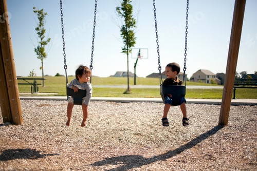 Preview: Two boys sitting in swings